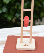Close up of the Nic climbing wooden ladder toy in action. The red peg doll figure can be seen tumbling down the ladder rungs. 