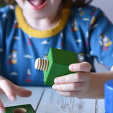 Child playing with pieces from the Nic screws and nuts colorful wooden toy threaded blocks and shapes set.
