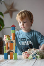 Child stacking the blocks from the Glückskäfer Wooden Bio Geometric Building Blocks, 58 Piece Set. 
