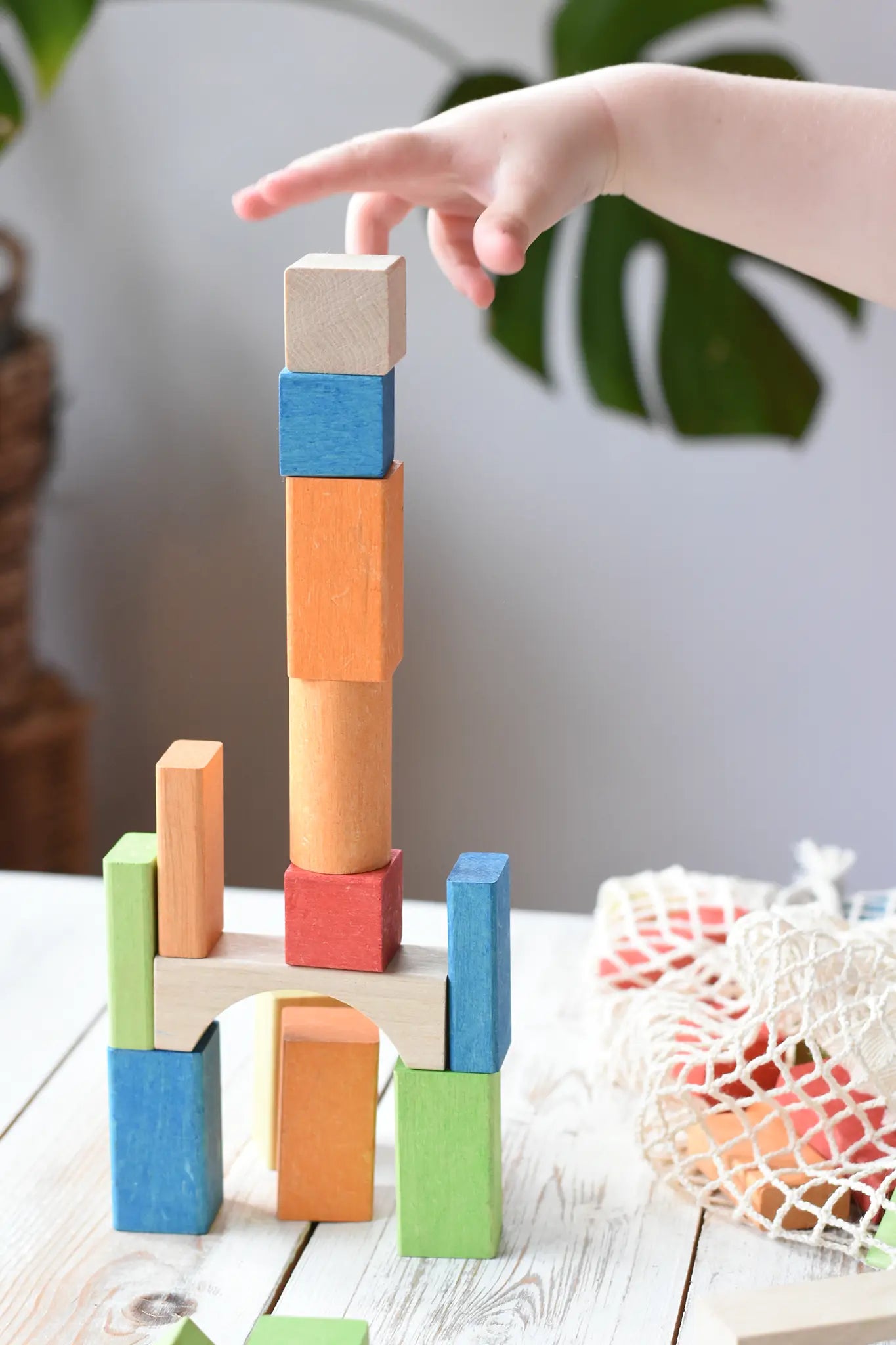 Child stacking the blocks from the Glückskäfer Wooden Bio Geometric Building Blocks. 58 Piece Set.
