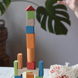 Child stacking the blocks from the Glückskäfer Wooden Bio Geometric Building Blocks, 58 Piece Set. 