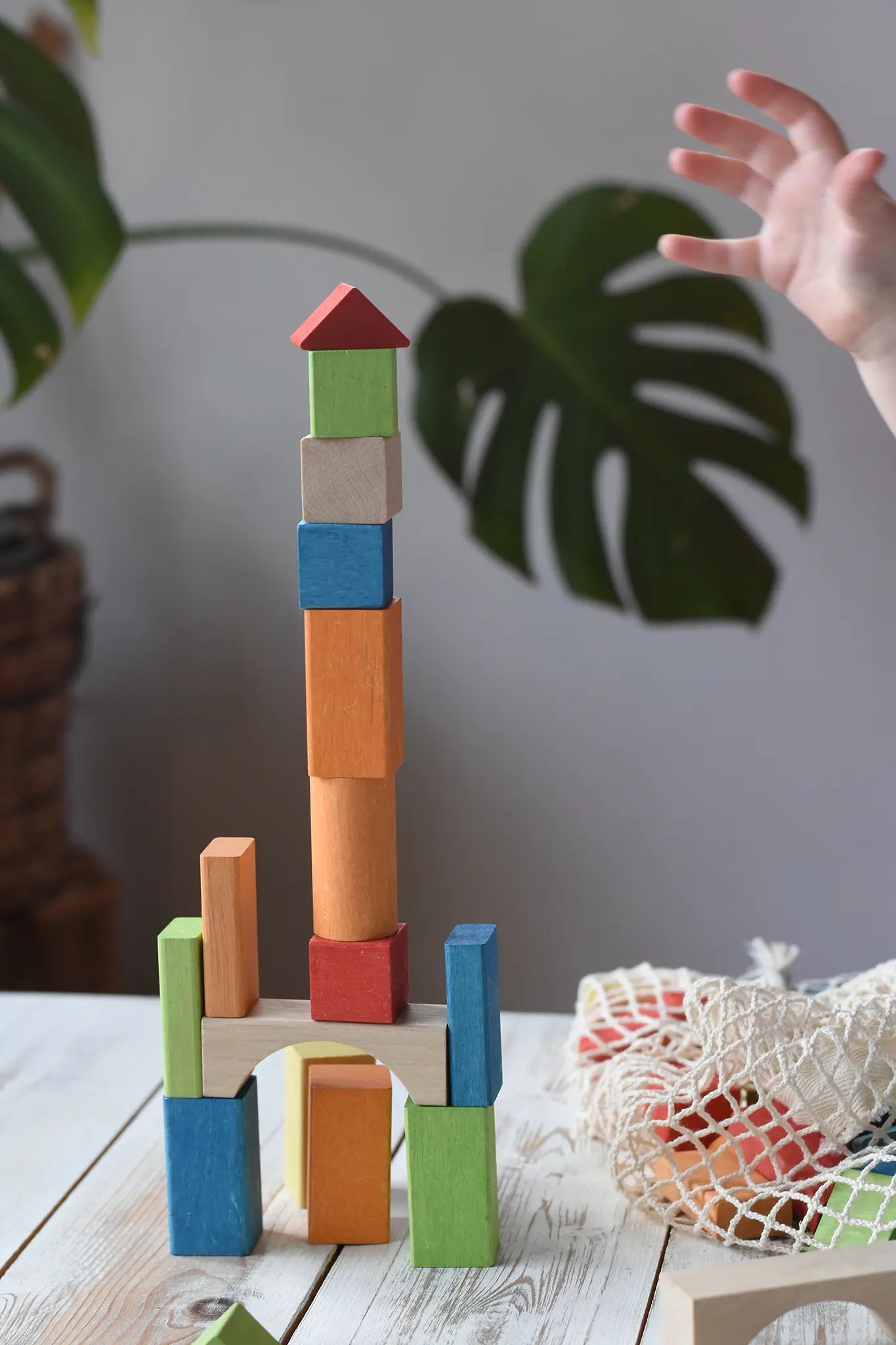 Child stacking the blocks from the Glückskäfer Wooden Bio Geometric Building Blocks, 58 Piece Set. 
