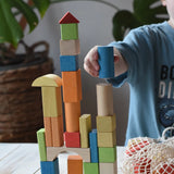 Child stacking the blocks from the Glückskäfer Wooden Bio Geometric Building Blocks, 58 Piece Set. 