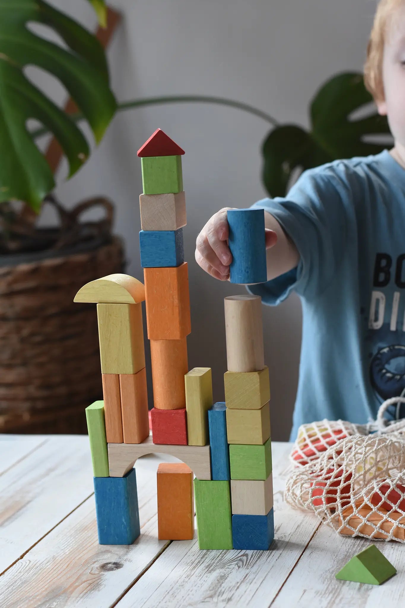Child stacking the blocks from the Glückskäfer Wooden Bio Geometric Building Blocks, 58 Piece Set. 