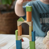 Child stacking the blocks from the Glückskäfer Wooden Bio Geometric Building Blocks, 58 Piece Set.