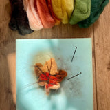 A small handcrafted Gluckskafer felted wool autumn leaf with Nic Toys felting needles.