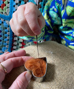 Child using Nic felting needle with Gluckskafer felt in a heart shape.