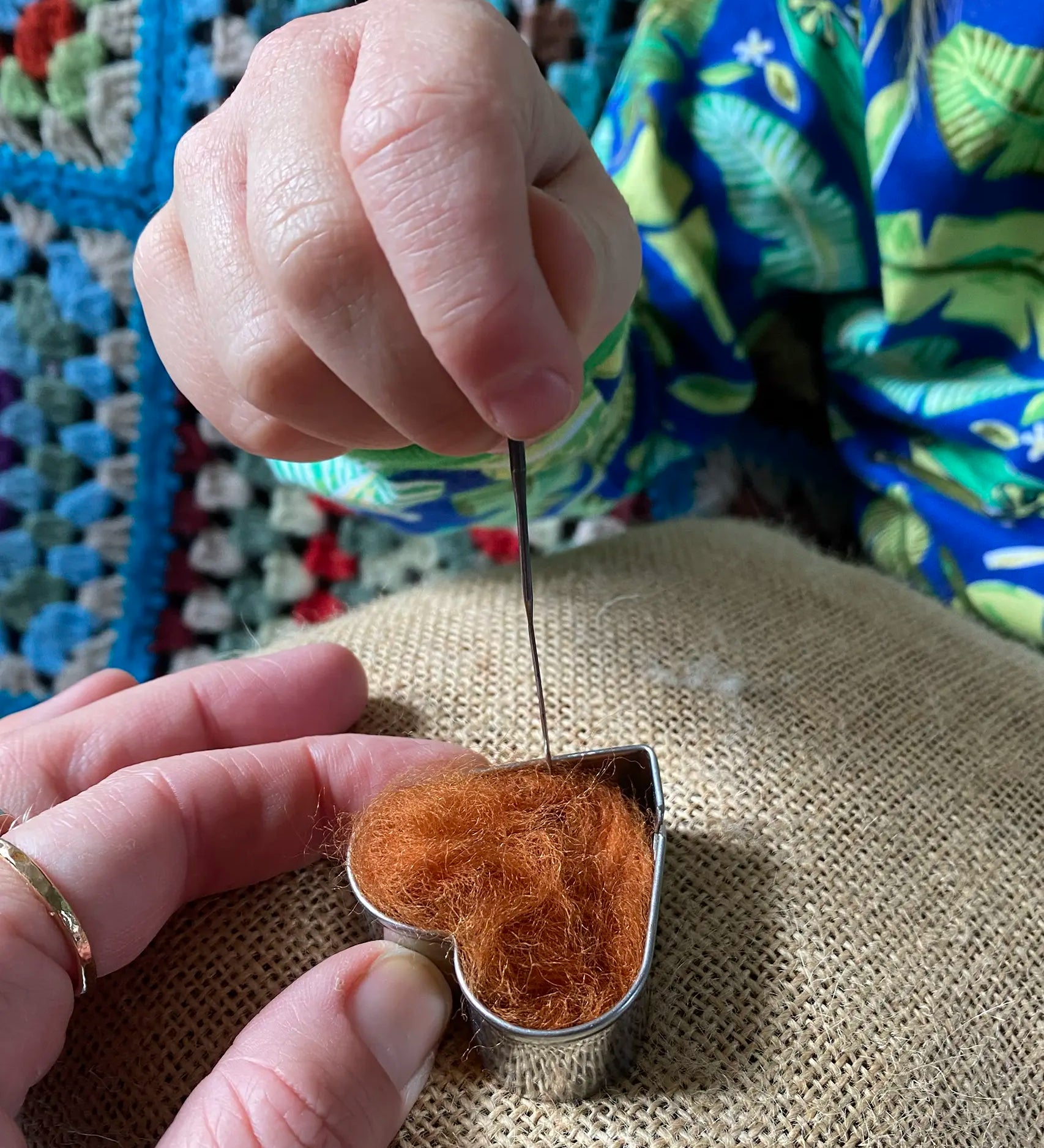 Child using Nic felting needle with Gluckskafer felt in a heart shape.