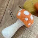 Nic felting needle next to a autumn toadstool made with Gluckskafer felt.