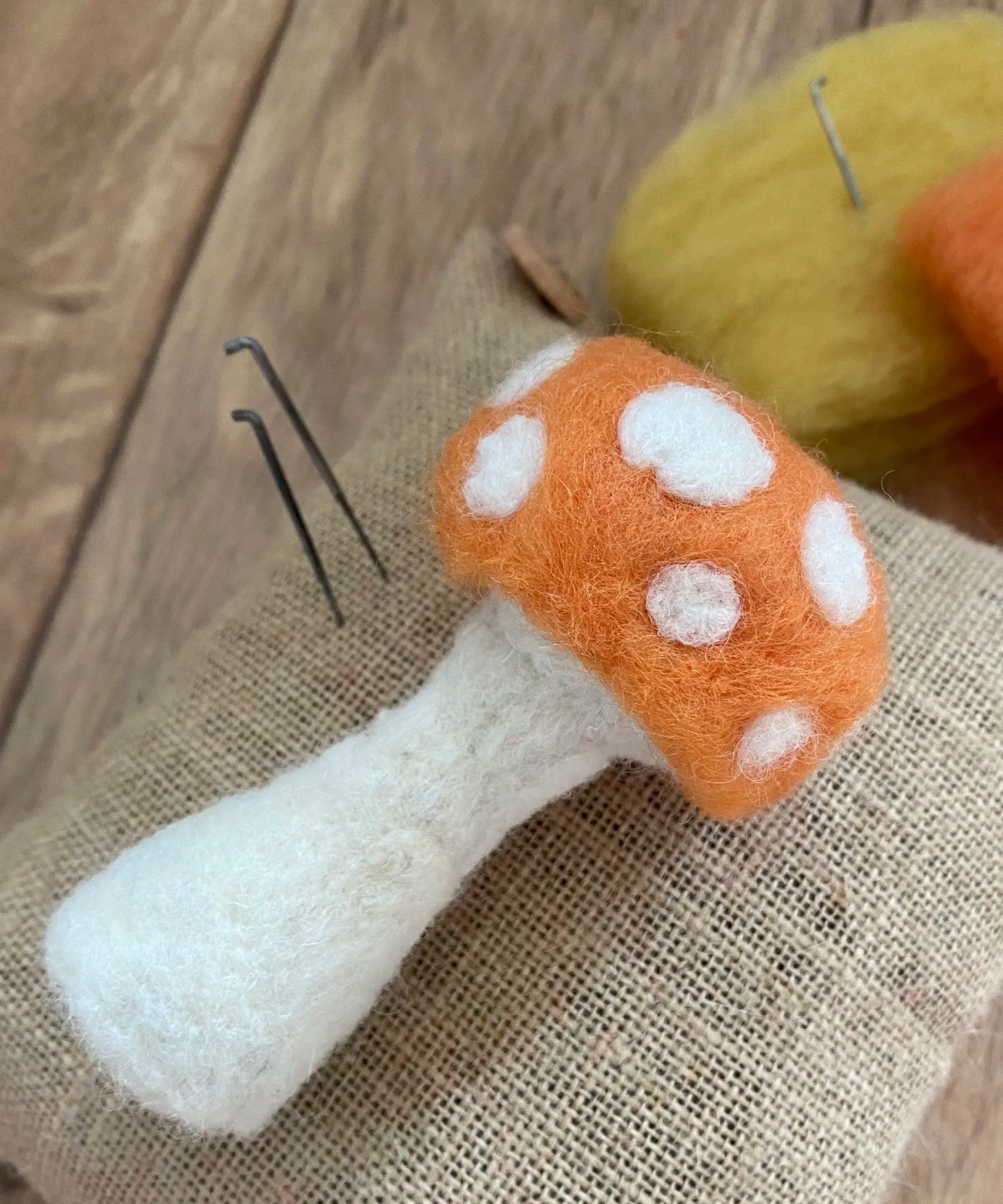 Nic felting needle next to a autumn toadstool made with Gluckskafer felt.