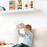 Nic Toys Rattle n Roll - a wooden musical rolling wheel toy for babies, shown with its natural finish, rainbow rungs and wooden marbles in a playroom setting.