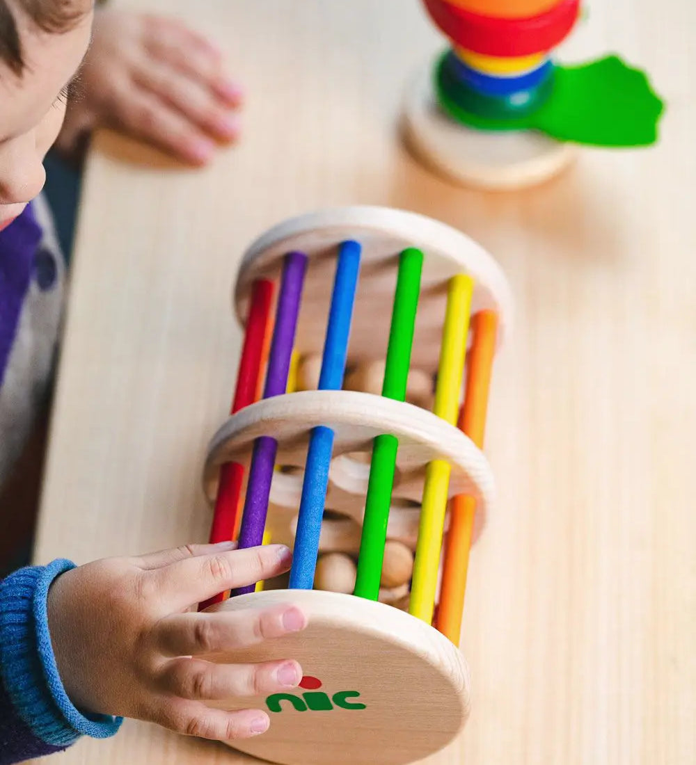 Nic Toys Rattle n Roll - a wooden rolling musical toy with a natural finish, colourful rainbow rungs and wooden marbles inside.
