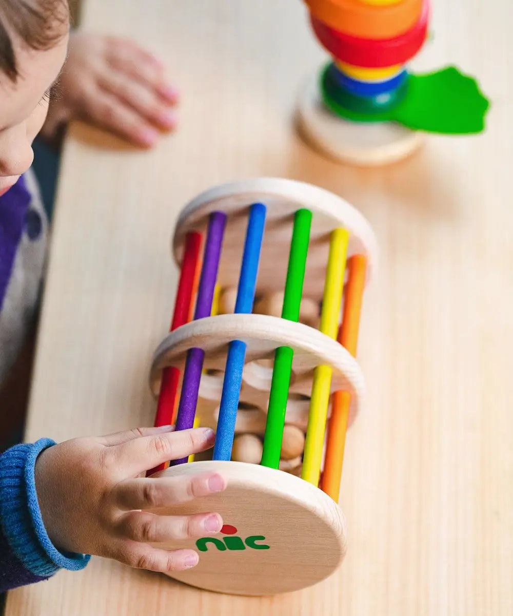 Nic Toys Rattle n Roll - a wooden rolling musical toy with a natural finish, colourful rainbow rungs and wooden marbles inside.