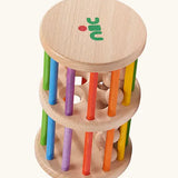 Nic Toys Rattle n Roll, a wooden rolling wheel musical toy for babies with rainbow stained rungs and natural wooden marbles.
