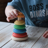 Child stacking colorful wooden rings on the Nic wooden Classic Stacking Tower baby toy natural wood base.