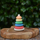 Baby wooden ring stacking toy by Nic Toys placed on a wooden board.