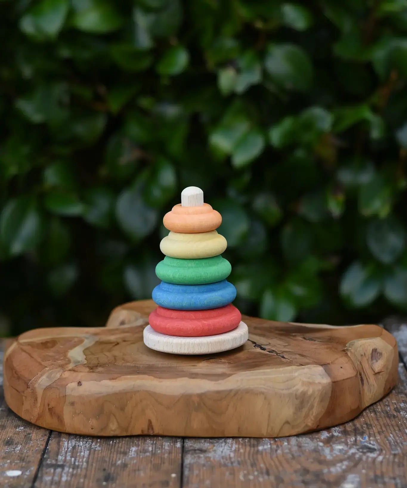 Baby wooden ring stacking toy by Nic Toys placed on a wooden board.