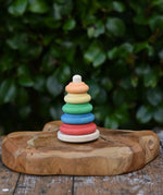Baby wooden ring stacking toy by Nic Toys placed on a wooden board.