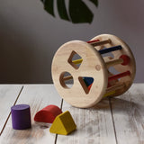 Nic rolling sorter wooden shape-sorting toy with colorful geometric blocks, displayed on a wooden table.