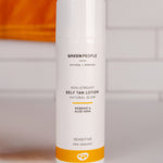 Green People Self Tan Lotion 150ml with an orange towel in the background