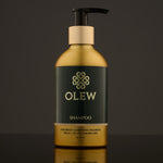 Olew Clarifying Shampoo, vegan haircare which is SLS and Paraben Free, in a gold and dark green bottle with a push down pump on top. The image is on a dark grey background