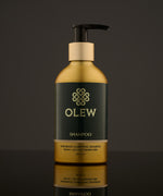 Olew Clarifying Shampoo, vegan haircare which is SLS and Paraben Free, in a gold and dark green bottle with a push down pump on top. The image is on a dark grey background