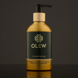 Olew naturally cleansing Conditioner, vegan haircare which is SLS and Paraben Free. In a gold and dark green bottle with a push down pump on top. The image is on a dark grey background