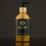 Olew Naturally Nourishing Curl Defining Cream, vegan haircare which is SLS and Paraben Free in a gold and dark green bottle with an push down pump top, on a dark grey background