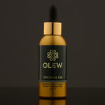 Olew Original Hair Oil, naturally moisturising vegan haircare which is SLS and Paraben Free, in a gold and dark green bottle with a pipette on top. The image is on a dark grey background