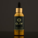 Olew Original Hair Oil, naturally moisturising vegan haircare which is SLS and Paraben Free, in a gold and dark green bottle with a pipette on top. The image is on a dark grey background