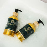 The Olew Shampoo and Conditioner gold and dark green bottles laying in bubbles, to give the feeling of cleanliness