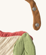 A close up of the  Oli & Carol Peppa the apple baby bib available at Babipur showing the popper fastener for size adjustment. 