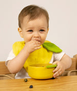A child eating fruit from the Oli & Carol Lou the lemon wooden bowl set available at Babipur. 