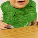 A close up of a baby wearing the Oli & Carol Kendall the kale organic cotton baby bib available at Babipur 