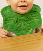 A close up of a baby wearing the Oli & Carol Kendall the kale organic cotton baby bib available at Babipur 