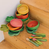 A stack of Oli Carol wooden bowls and plates on stairs. All bowls and plates are available at Babipur.