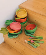 A stack of Oli Carol wooden bowls and plates on stairs. All bowls and plates are available at Babipur.