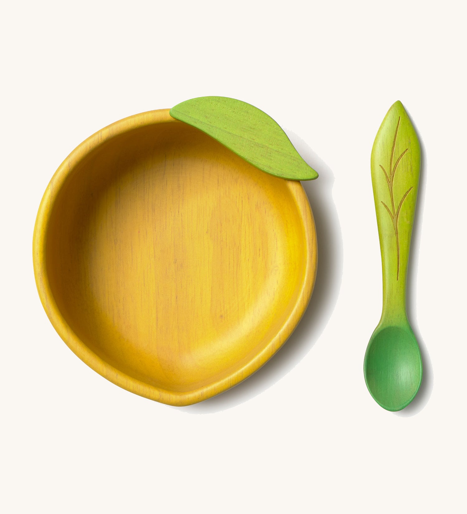 Oli & Carol Lou the lemon wooden bowl and spoon set available at Babipur. Features a decorative green leaf on the bowl.