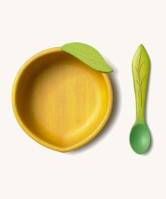 Oli & Carol Lou the lemon wooden bowl and spoon set available at Babipur. Features a decorative green leaf on the bowl.