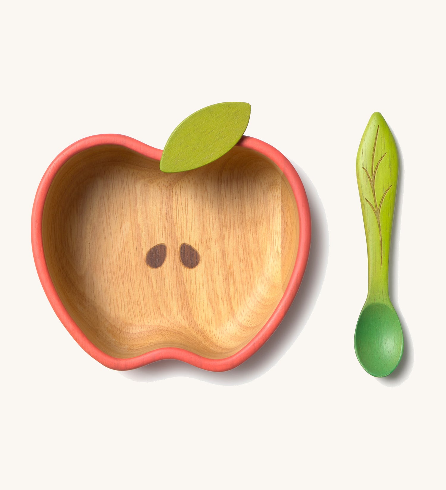 Oli & Carol Peppa the apple wooden bowl and spoon set available at Babipur.  The bowl is in a shape of a apple cut in half and features a decorative green leaf on the bowl.