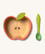 Oli & Carol Peppa the apple wooden bowl and spoon set available at Babipur.  The bowl is in a shape of a apple cut in half and features a decorative green leaf on the bowl.