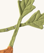 A close up of the  Oli & Carol Cathy the carrot baby bib available at Babipur showing the popper fastener for size adjustment. 