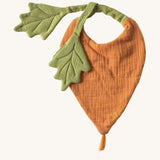 Oli & Carol Cathy the carrot baby bib available at Babipur. A organic cotton bib in a shape of a orange carrot  Features a popper fastener. 
