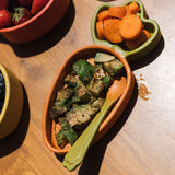 A close up of the Oli & Carol Cathy the carrot wooden plate filled with food in both dividers available at Babipur. 