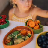A close up of the Oli & Carol Cathy the carrot wooden plate filled with food available at Babipur. 