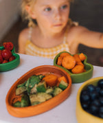A close up of the Oli & Carol Cathy the carrot wooden plate filled with food available at Babipur. 
