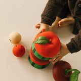 A child stacking the apple, watermelon and cherry Oli & Carol stacking toy rattles. Each fruit is available at Babipur.