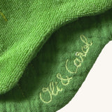 A close up of the  Oli & Carol Kendall the kale baby bib available at Babipur showing the brand name stitch detail on the inside of the bib