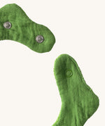 A close up of the  Oli & Carol Kendall the kale baby bib available at Babipur showing the popper fastener for size adjustment. 