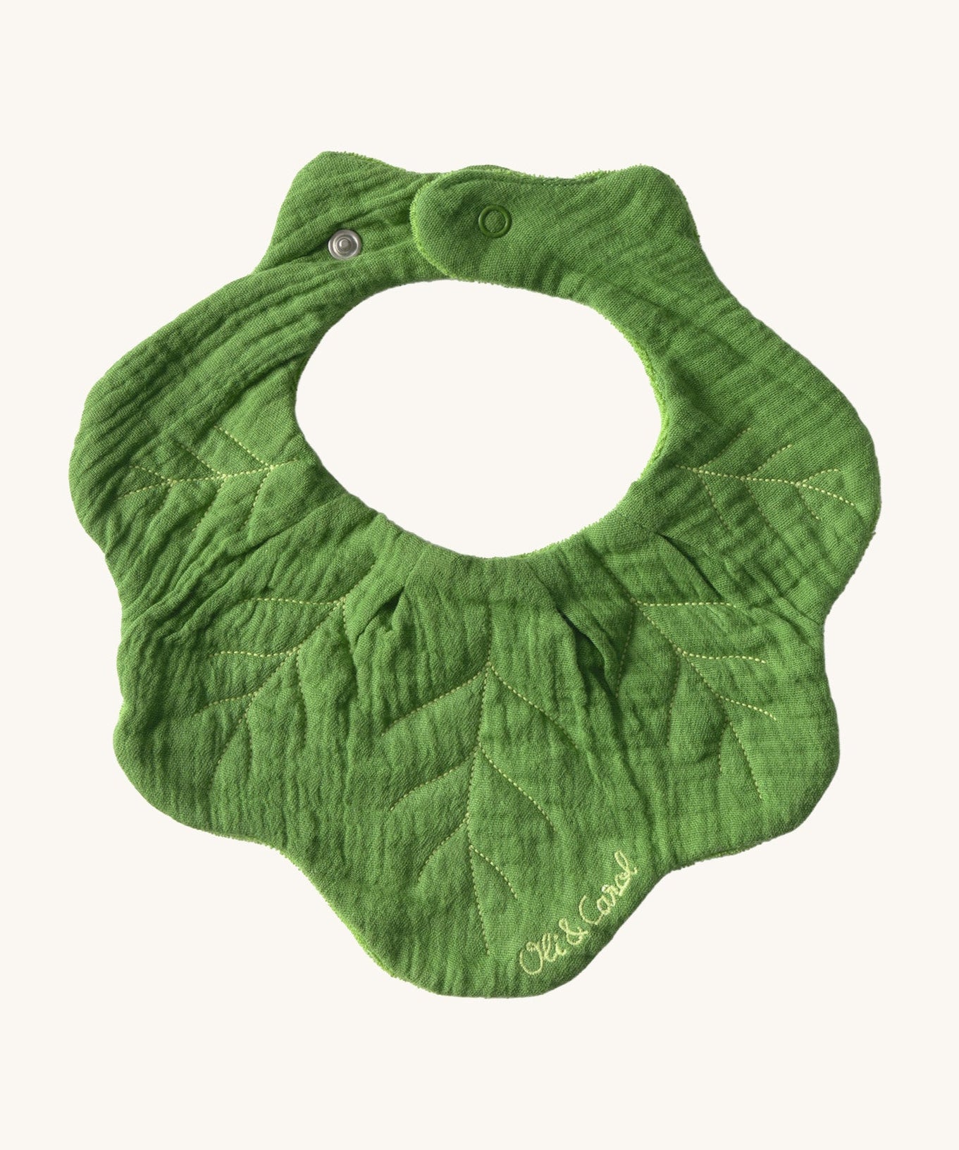 Oli & Carol Kendal the kale baby bib available at Babipur. A organic cotton bib in a shape of green kale. Features a popper fastener. 